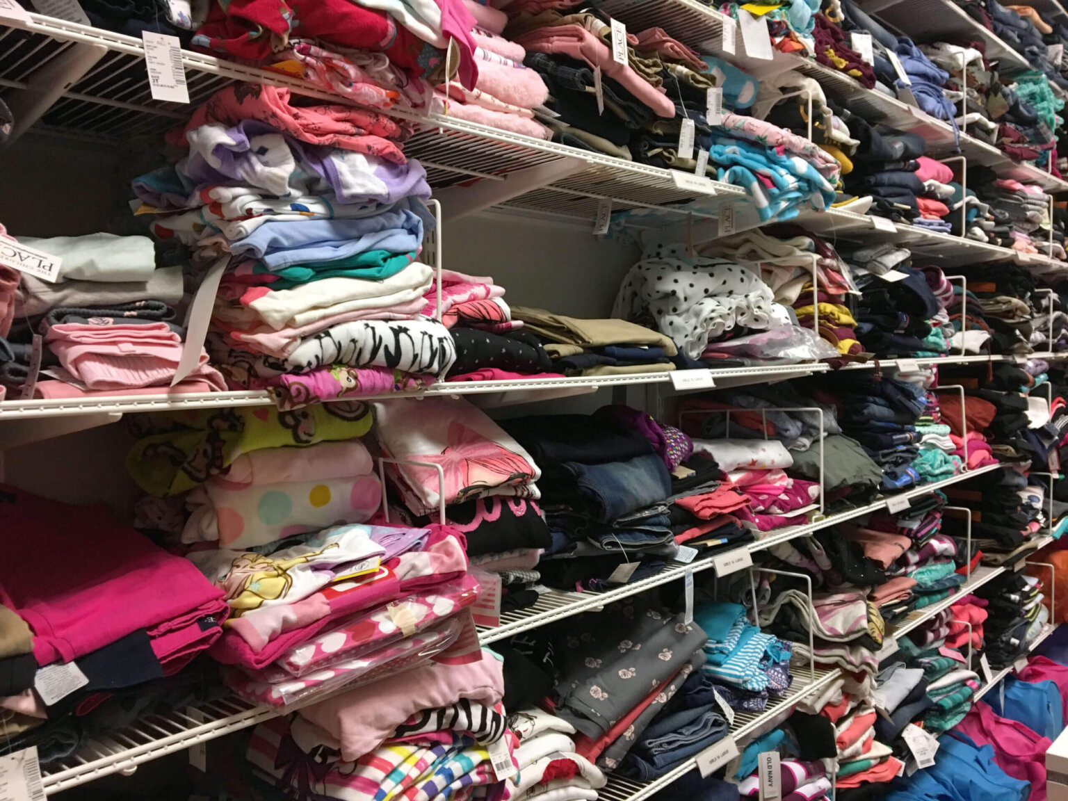 Stacks of clothes in the Safe Shores Clothing Closet