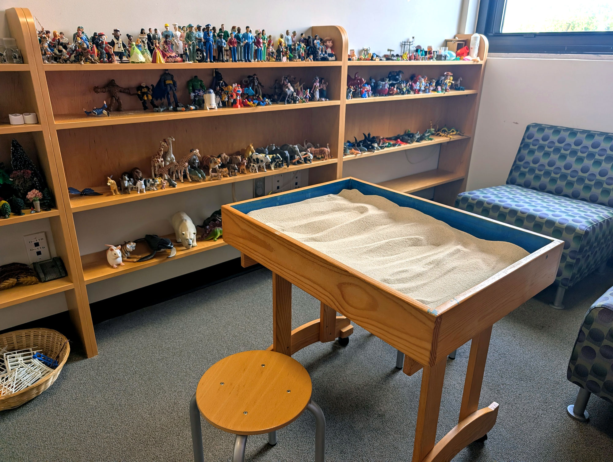 The Safe Shores sand tray room, with shelves full of toys and action figures